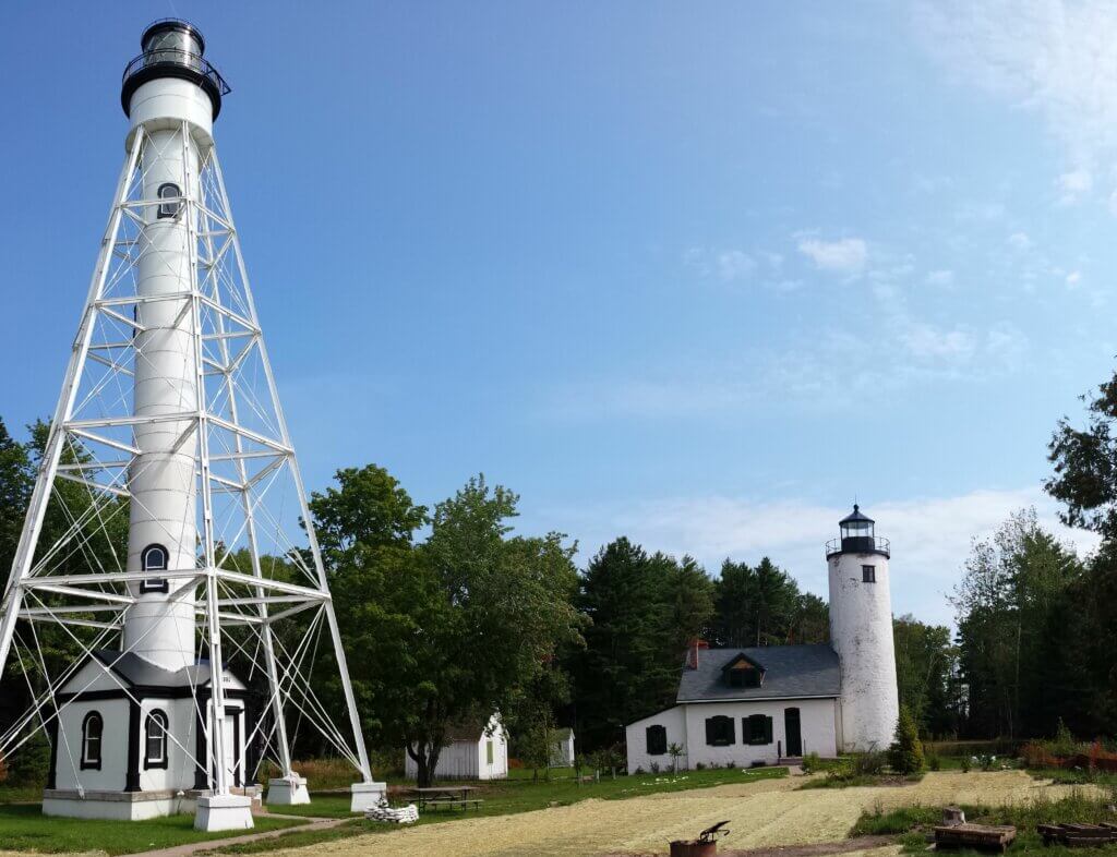 White and black lighthouses settled among a forest.
