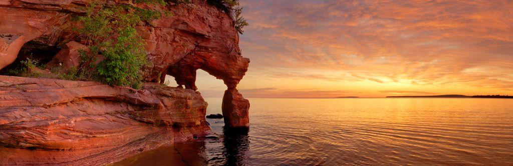 Red caves over water at sunset.