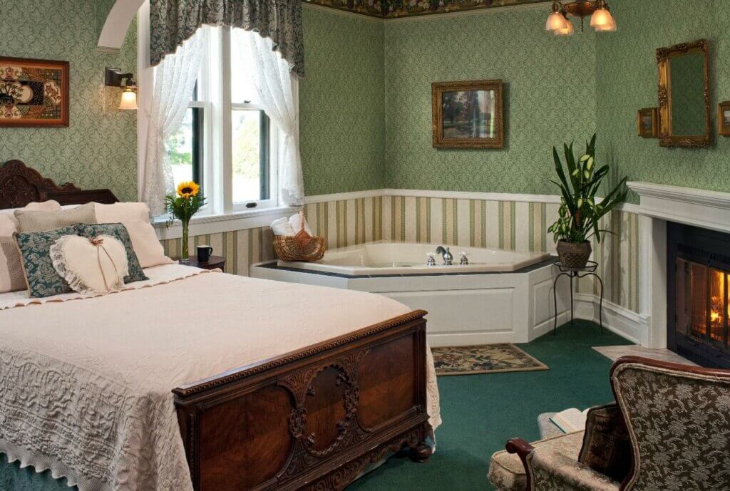 Vintage room with green and white wallpaper, fireplace, and jacuzzi.