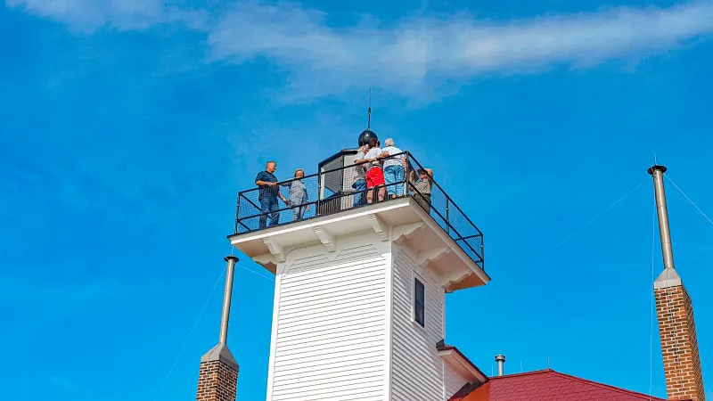 A National Park ranger taking a group photo of visitors from atop the Raspberry Island Lighthouse